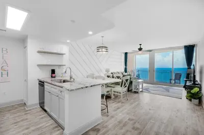 a kitchen and dining room with a view of the ocean at Aqua Resort 1705 in Panama City Beach