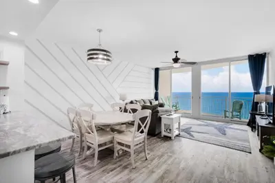 a living room with a table and chairs and the ocean at Aqua Resort 1705 in Panama City Beach