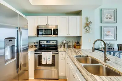 a kitchen with a stainless steel stove and a sink at Beachfront PCB Condo with Ocean View and Pool Access! in Panama City Beach