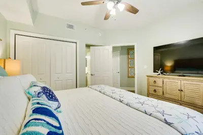 a bedroom with a large bed and a ceiling fan at Beachfront PCB Condo with Ocean View and Pool Access! in Panama City Beach