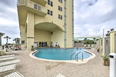 a swimming pool in front of a building at Beachfront PCB Condo with Ocean View and Pool Access! in Panama City Beach