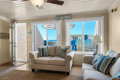 a living room with a couch and a chair and a window at 111 The Shores in Sunnyside