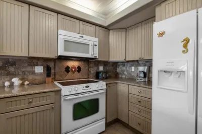 a kitchen with white appliances and a white refrigerator at 111 The Shores in Sunnyside