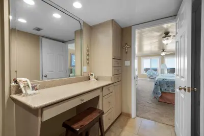 a bathroom with a sink and a mirror and a bedroom at 111 The Shores in Sunnyside
