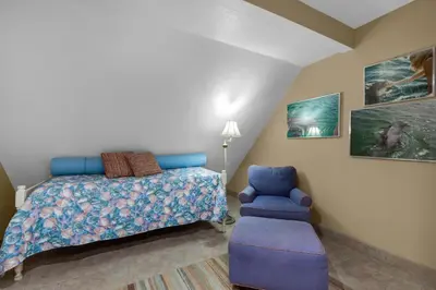 a bedroom with a bed and a blue chair at 111 The Shores in Sunnyside