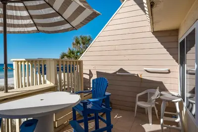 a patio with chairs and a table and an umbrella at 111 The Shores in Sunnyside