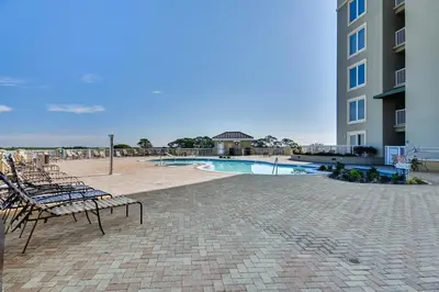 a group of chairs sitting next to a swimming pool at Grand Panama Beach Resort #908-1 by Book That Condo in Panama City Beach