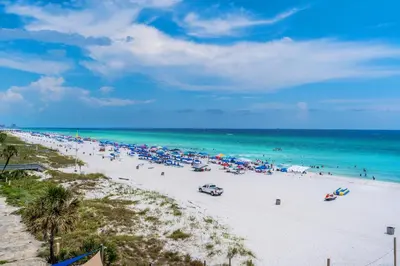 a beach with a lot of umbrellas and the ocean at Grandview East 302 - Sandscape in Panama City Beach