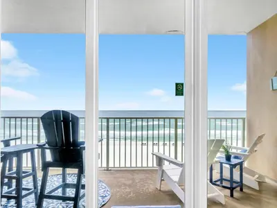 a room with a balcony with a view of the ocean at Grandview East 302 - Sandscape in Panama City Beach
