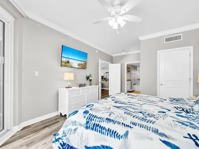 a white bedroom with a bed and a ceiling fan at Grandview East 302 - Sandscape in Panama City Beach