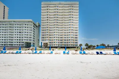 a group of beach chairs and umbrellas on the beach at Grandview East 302 - Sandscape in Panama City Beach