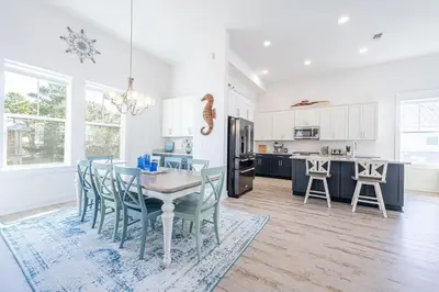 a kitchen and dining room with a table and chairs at Vitamin Sea in Inlet Beach