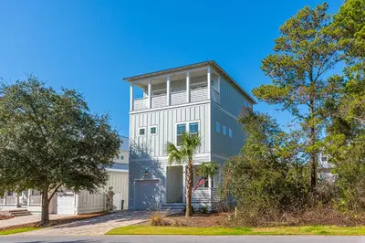 a white and gray house with a tree at Vitamin Sea in Inlet Beach