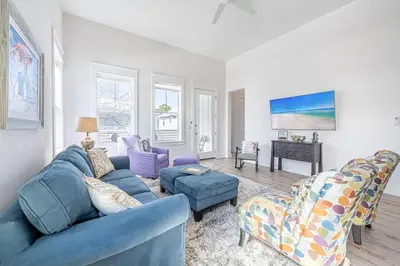 a living room with a blue couch and chairs at Vitamin Sea in Inlet Beach