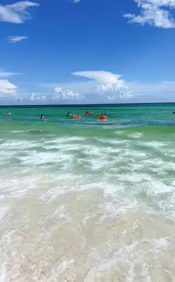 a group of people swimming in the ocean at Beach Room, for wonderful Vacation in Panama City Beach