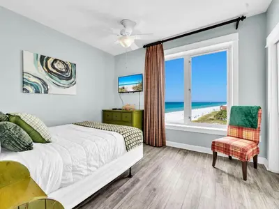 a bedroom with a bed and a view of the ocean at Grand Panama 1-1401 in Panama City Beach