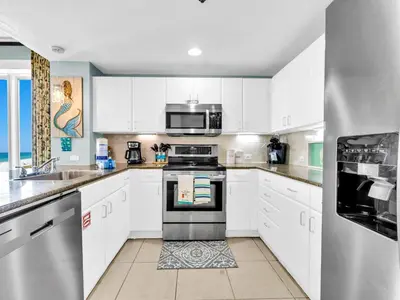 a kitchen with white cabinets and a stove top oven at Grand Panama 1-1401 in Panama City Beach