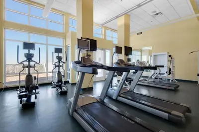 a gym with treadmills and ellipticals in a building at Grand Panama 1-1401 in Panama City Beach
