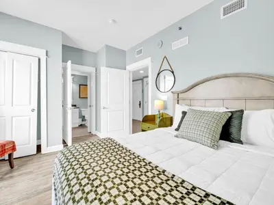 a bedroom with a white bed with a checkered blanket at Grand Panama 1-1401 in Panama City Beach
