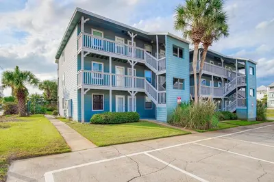 a blue apartment building with balconies and palm trees at Inlet Sands 206- Inlet Dreams in Panama City Beach