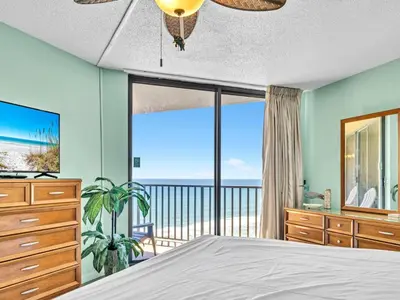 a bedroom with a bed and a view of the ocean at Summerhouse 1009B in Panama City Beach