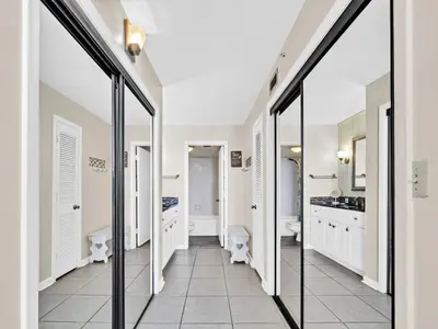 a bathroom with glass doors and white cabinets at Summerhouse 1009B in Panama City Beach