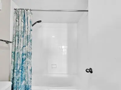 a shower with a blue and white shower curtain at Summerhouse 1009B in Panama City Beach