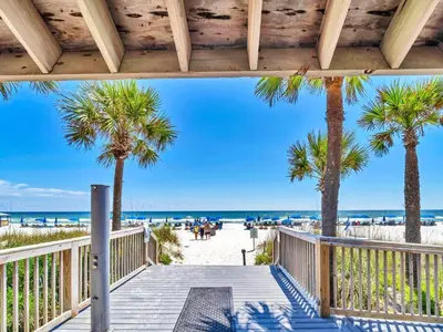 a boardwalk leading to the beach with palm trees at Summerhouse 1009B in Panama City Beach