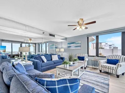 a living room with blue furniture and a ceiling fan at Watercrest 103 in Panama City Beach