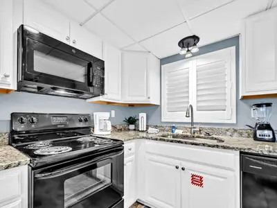 a kitchen with a stove and a microwave at Watercrest 103 in Panama City Beach