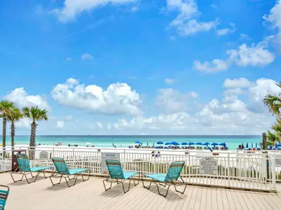 a deck with chairs and the beach in the background at Watercrest 103 in Panama City Beach