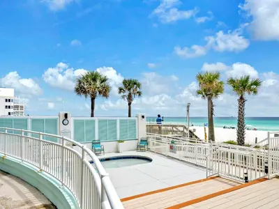 a pool with palm trees and the beach at Watercrest 103 in Panama City Beach