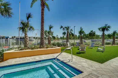 a swimming pool with palm trees in a park at Calypso Resort Tower 3 in Panama City Beach