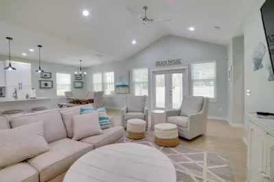 a living room with a white couch and chairs at West End Home with Yard Less Than 1 Mi to Beach Access! in Panama City Beach