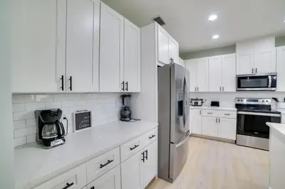 a kitchen with white cabinets and a stainless steel refrigerator at West End Home with Yard Less Than 1 Mi to Beach Access! in Panama City Beach