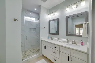 a white bathroom with a shower and a sink at West End Home with Yard Less Than 1 Mi to Beach Access! in Panama City Beach