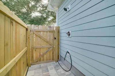 a wooden door with a hose attached to a fence at West End Home with Yard Less Than 1 Mi to Beach Access! in Panama City Beach
