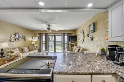 a kitchen with a counter top and a living room at Sea Hag by Book That Condo in Panama City Beach