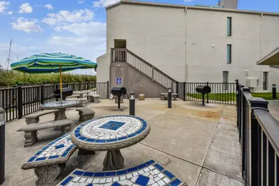 a patio with two tables and an umbrella at Sea Hag by Book That Condo in Panama City Beach