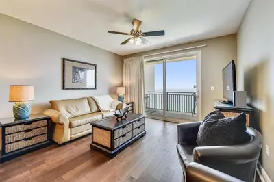 a living room with a couch and a tv at Sterling Breeze #1702 by Book That Condo in Panama City Beach