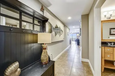 a hallway with a table with a lamp on it at Sterling Breeze #1702 by Book That Condo in Panama City Beach