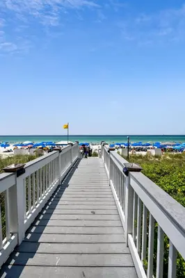 a boardwalk leading to the beach on a sunny day at Sterling Breeze #1702 by Book That Condo in Panama City Beach