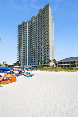 a beach with umbrellas and a large building at Sterling Breeze #1702 by Book That Condo in Panama City Beach