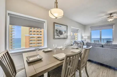 a dining room with a table and chairs and a couch at Calypso Resort and Towers #1101-3 by Book That Condo in Panama City Beach