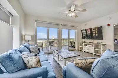 a living room with a blue couch and a ceiling fan at Calypso Resort and Towers #1101-3 by Book That Condo in Panama City Beach