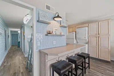 a kitchen with a counter and stools in it at The Summit 919 in Panama City Beach