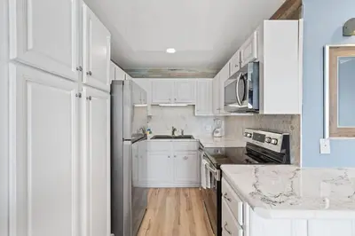a white kitchen with white cabinets and a sink at The Summit 1408 in Panama City Beach
