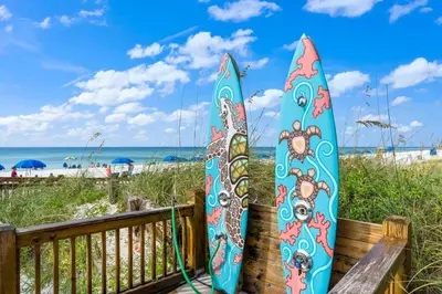 two surfboards are leaning against a fence at the beach at The Summit 1408 in Panama City Beach