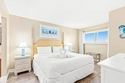 a bedroom with a white bed with a stuffed animal on it at The Summit 820 in Panama City Beach