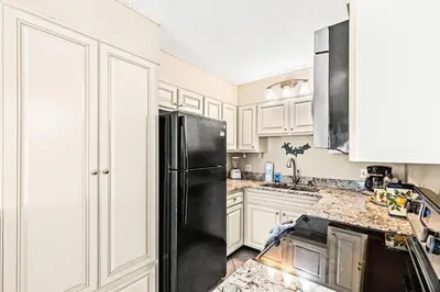 a kitchen with white cabinets and a black refrigerator at The Summit 820 in Panama City Beach